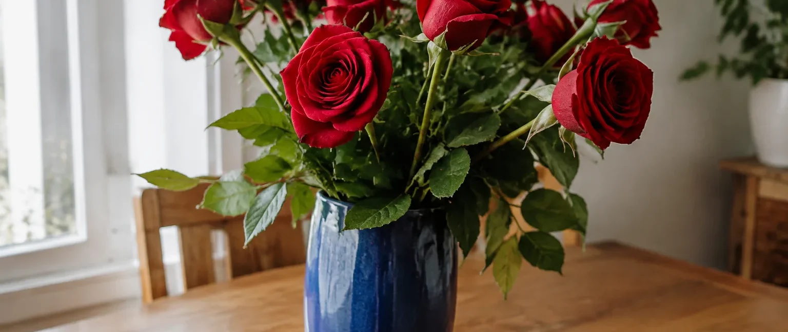 Bouquet de roses rouges dans un vase bleu