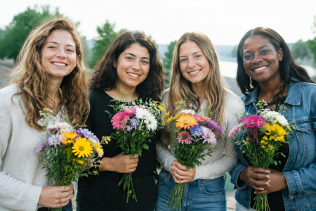 Groupe femmes debout tenant fleurs multicolores
